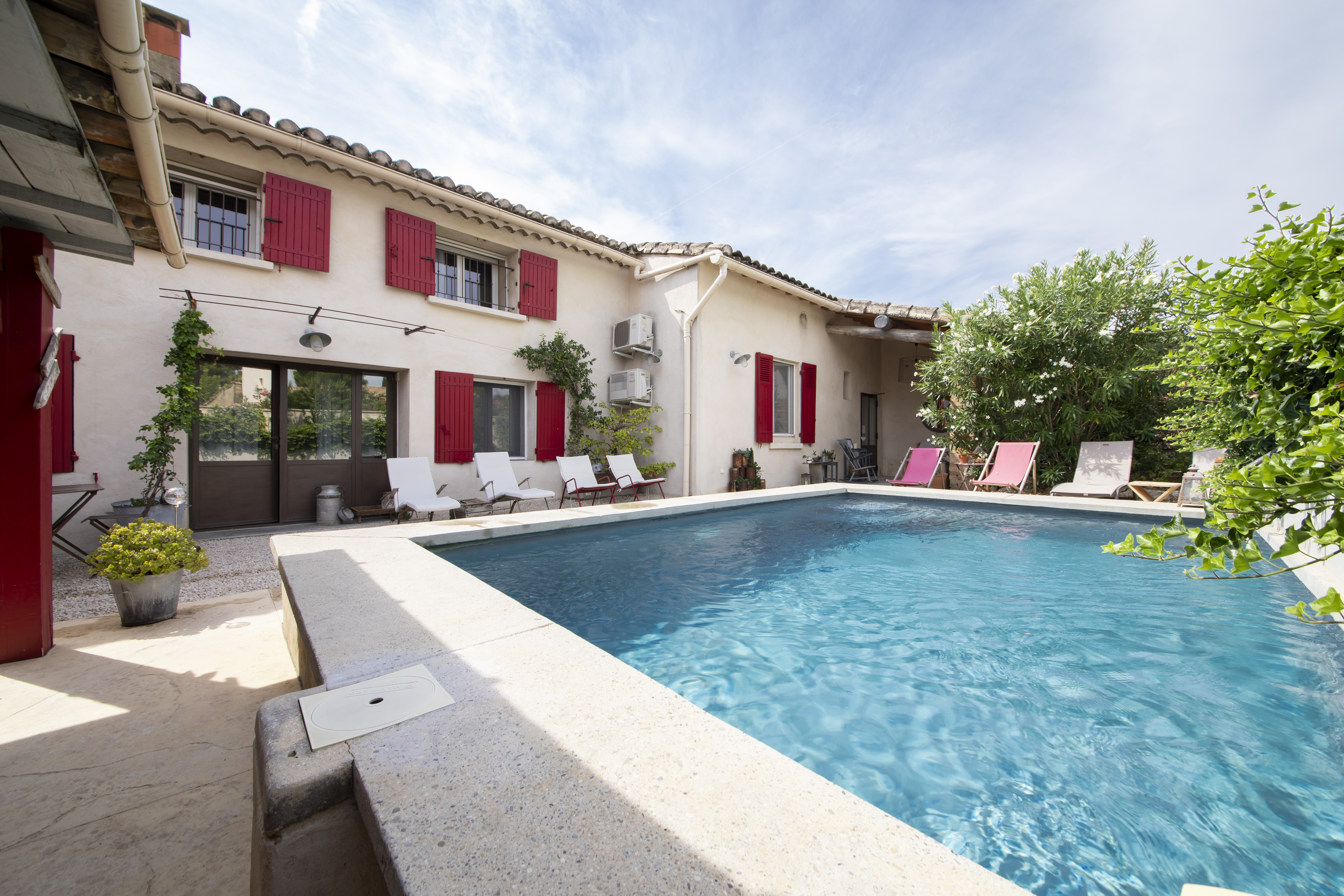 L’ORÉLIANE_10 Piscine extérieure et façade aux volets rouges de L'Oréliane en Provence
